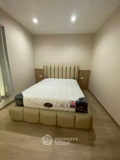 Modern bedroom with stylish bed and wooden flooring, perfect for a cozy retreat.