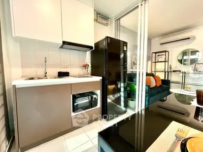 Modern kitchen with sleek appliances and open layout leading to cozy living area.