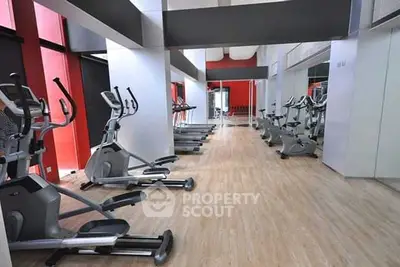 Modern gym with sleek exercise equipment and mirrored walls in a stylish residential building.