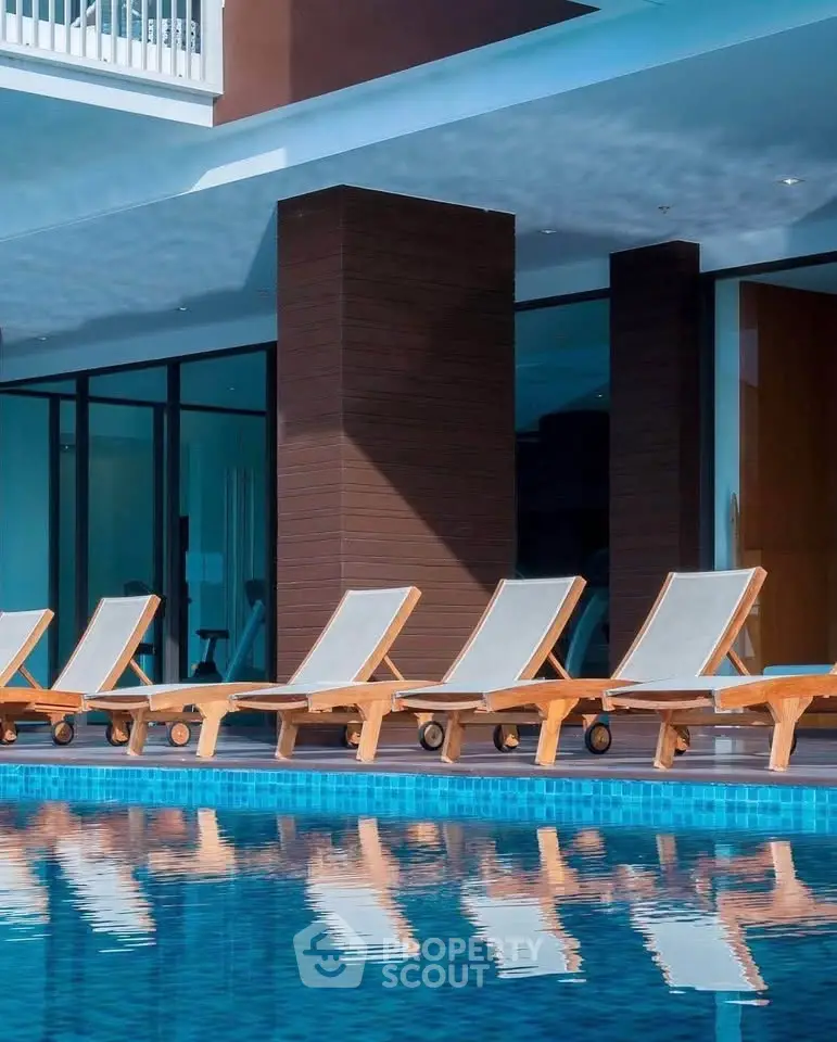 Luxurious poolside area with modern lounge chairs and sleek architectural design.