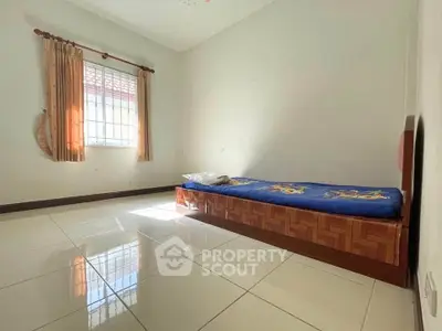 Spacious bedroom with single bed and natural light through window
