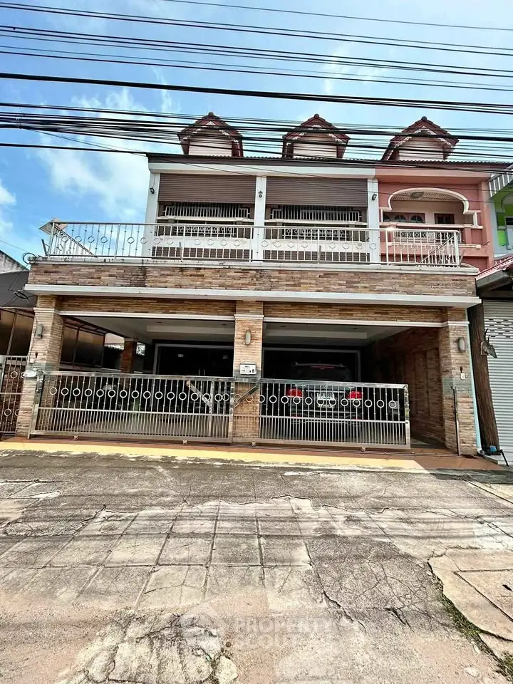 Charming two-story townhouse with spacious balcony and gated parking area.