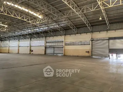 Spacious industrial warehouse with high ceilings and large roller doors