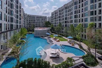 Luxurious apartment complex with stunning pool and lush greenery, perfect for modern living.