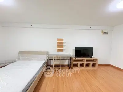 Spacious studio apartment with modern furnishings and wooden flooring, ideal for comfortable living.