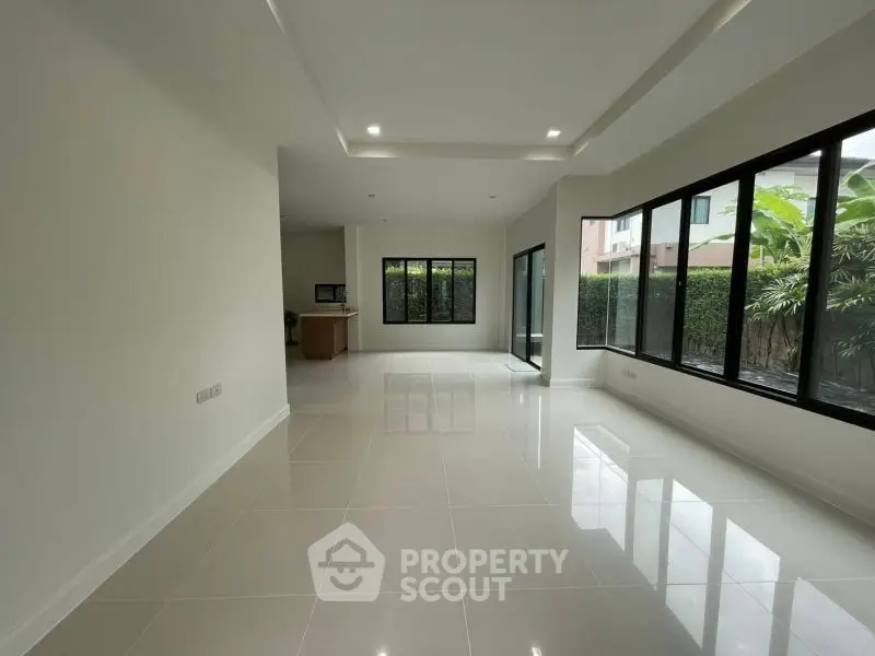 Spacious modern living room with large windows and glossy tile flooring