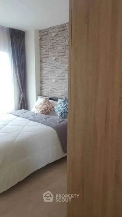 Cozy bedroom with modern decor and textured accent wall, perfect for relaxation.