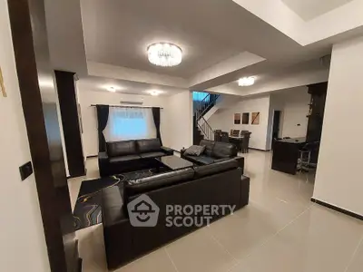 Spacious modern living room with elegant black leather sofas and stylish lighting