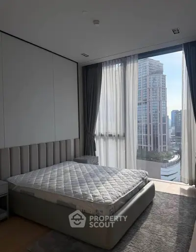 Luxurious bedroom with stunning city view and modern decor in high-rise apartment.