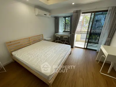 Modern bedroom with balcony access and wooden flooring