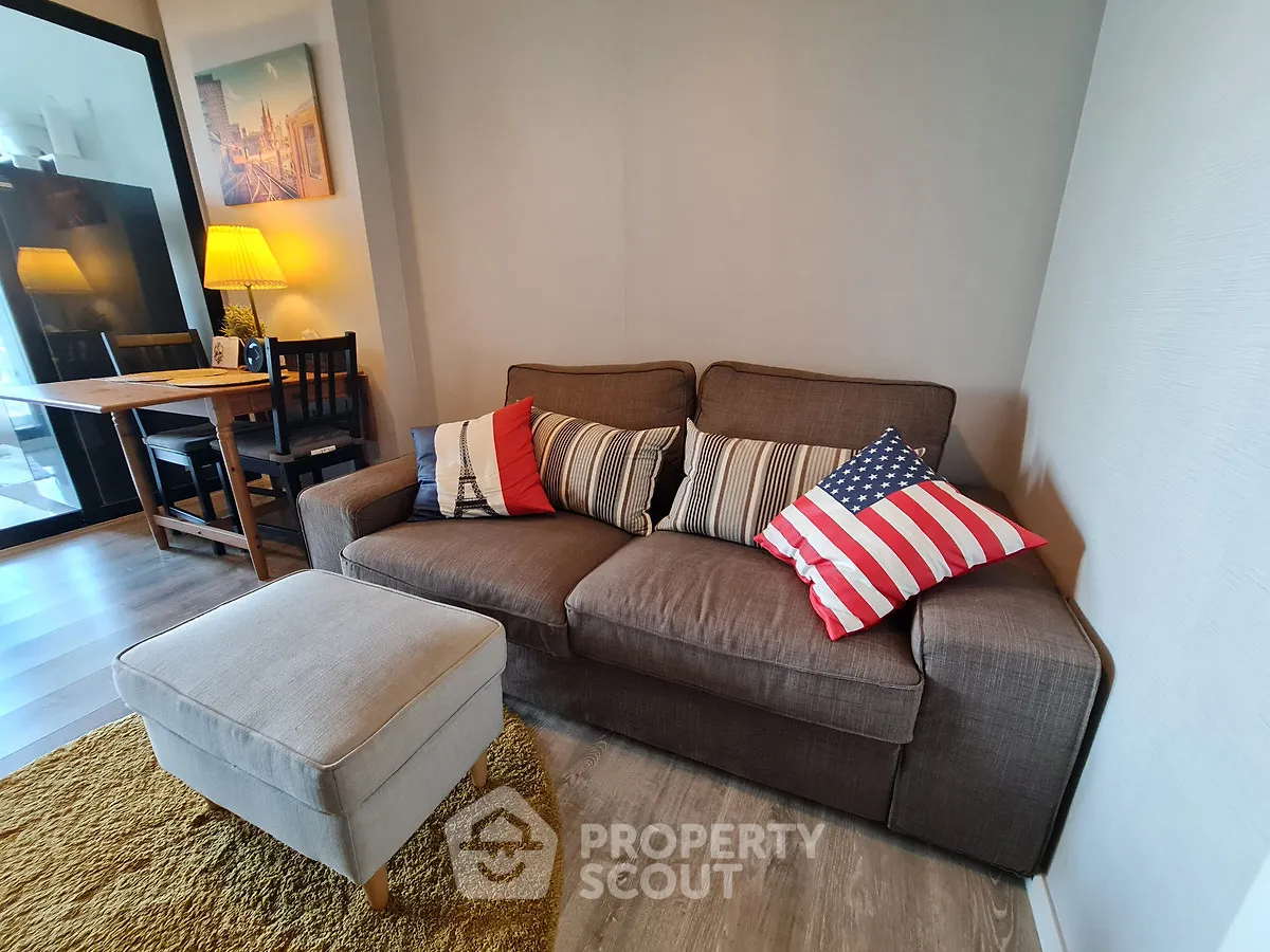 Cozy living room with stylish sofa and dining area, perfect for relaxation and entertaining.