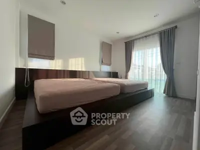 Spacious bedroom with twin beds and large windows for natural light