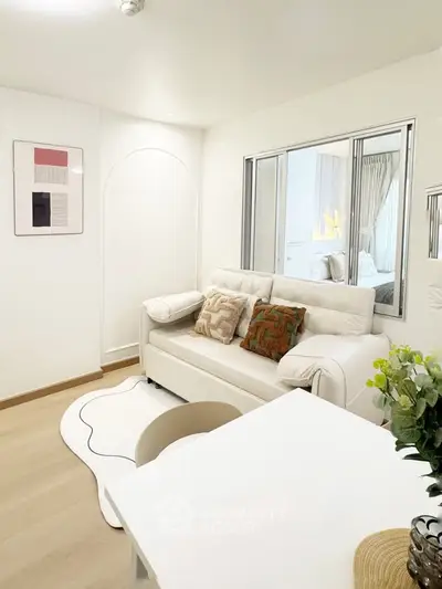 Modern living room with white sofa, stylish decor, and cozy ambiance in a contemporary apartment.