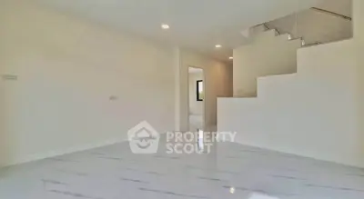Spacious modern interior with sleek staircase and polished flooring, ideal for contemporary living.