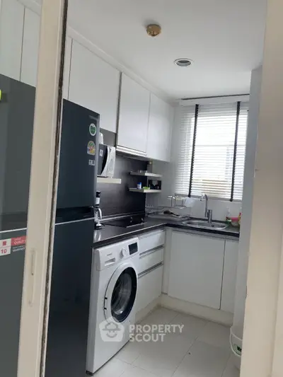 Modern compact kitchen with washing machine and sleek cabinetry