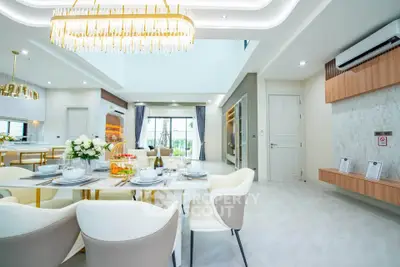 Luxurious open-plan living and dining area with elegant chandelier and modern decor.