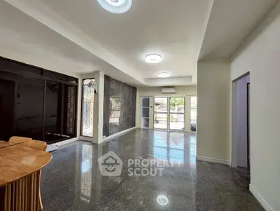 Spacious modern living room with large windows and glossy floors