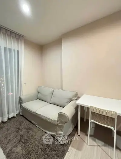 Cozy living room with a plush sofa and a small study table, perfect for urban living.