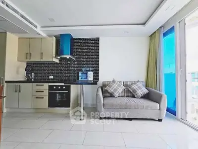 Modern open-plan kitchen with sleek black backsplash and cozy seating area.
