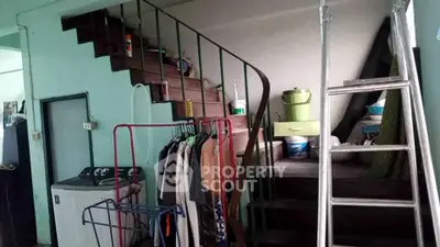 Cozy interior with spiral staircase and laundry area, perfect for compact living spaces.