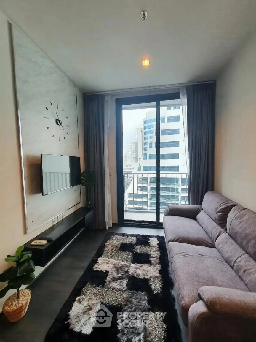 Modern living room with stylish decor and city view balcony in high-rise apartment.
