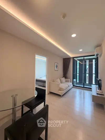Modern living room with sleek design and balcony access in a stylish apartment.