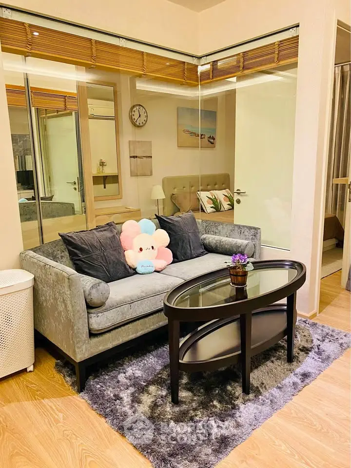 Chic living room with plush sofa, glass coffee table, and cozy decor in modern apartment.