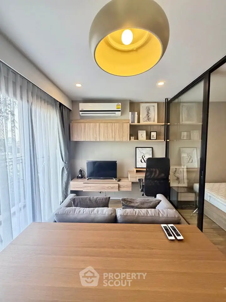 Modern living room with stylish decor, large window, and sleek furniture in a contemporary apartment.