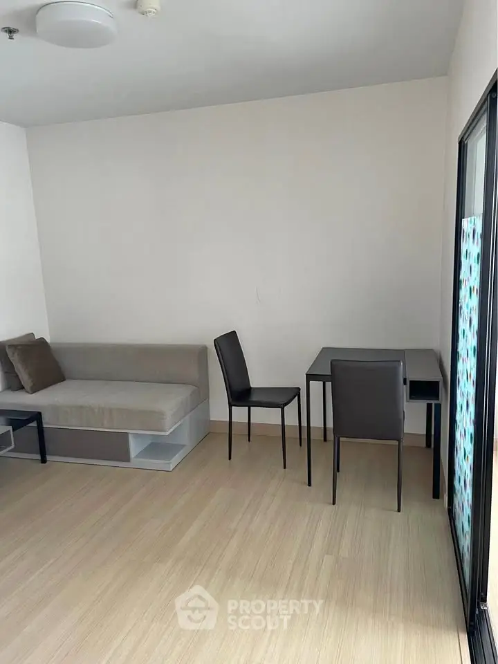 Modern minimalist living room with sleek furniture and light wood flooring.