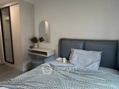 Modern bedroom with stylish decor and cozy ambiance, featuring a sleek bed and elegant furnishings.