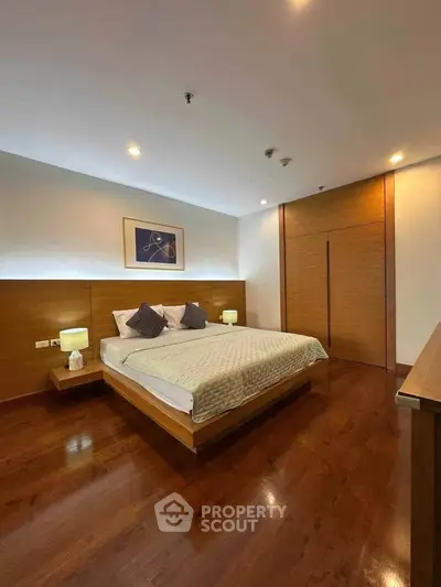 Spacious modern bedroom with wooden flooring and elegant decor