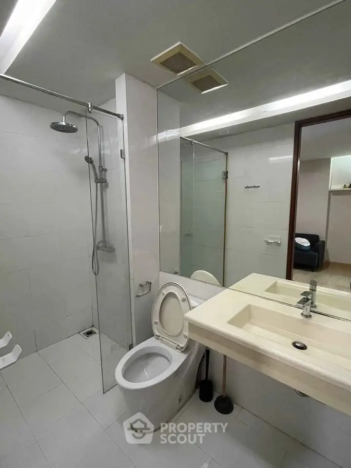 Modern bathroom with glass shower and sleek fixtures in a contemporary apartment.