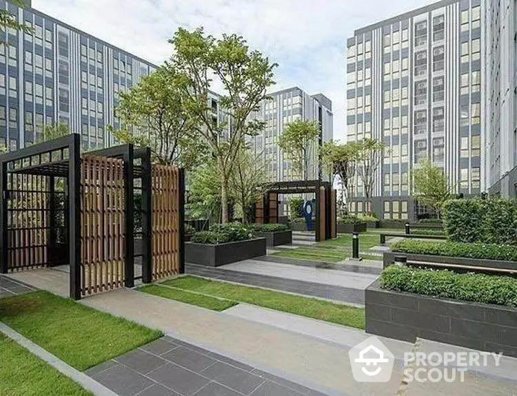 Modern urban garden with sleek design and lush greenery in a residential complex.