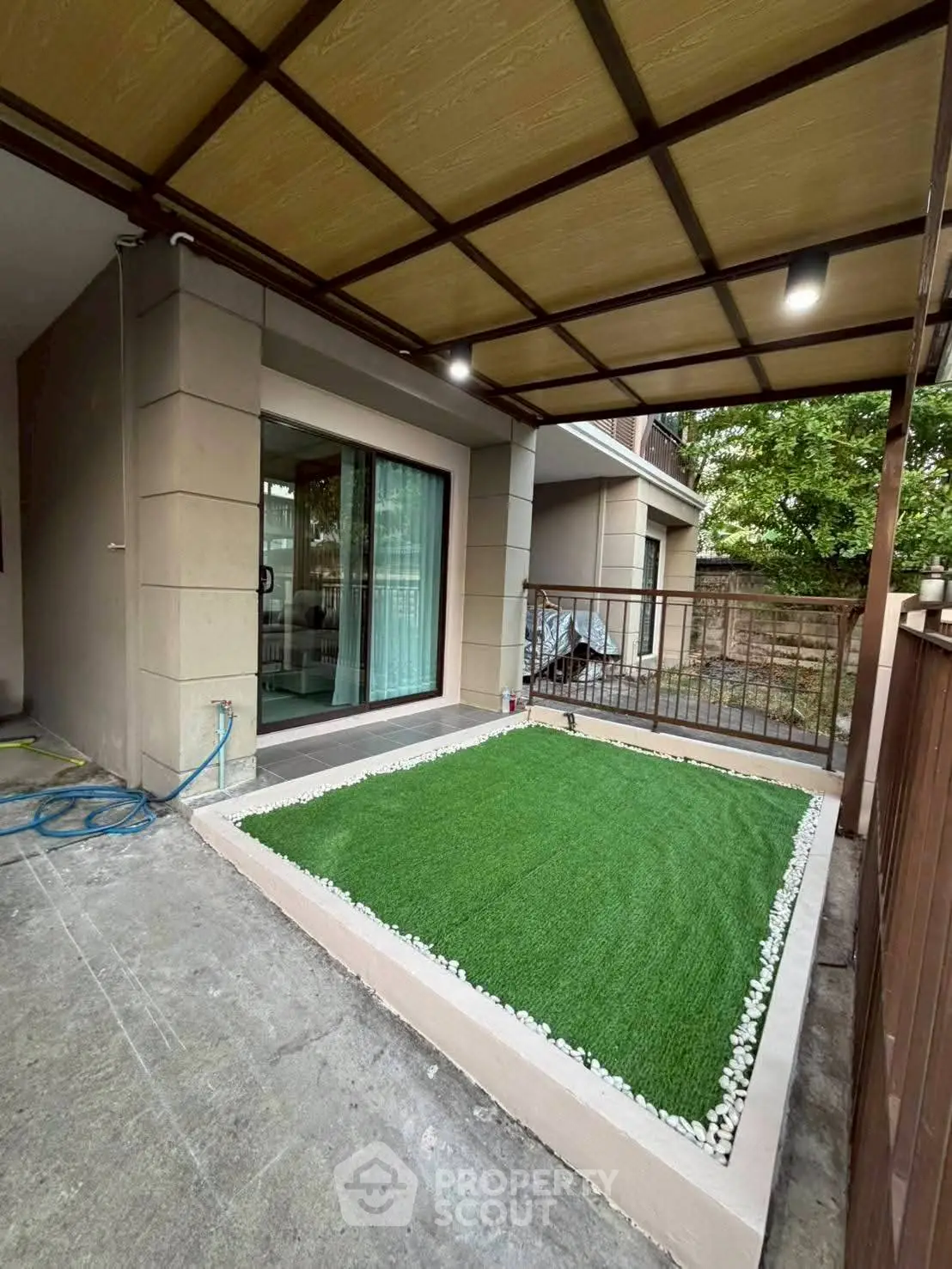 Charming patio with artificial grass and modern sliding doors, perfect for outdoor relaxation.