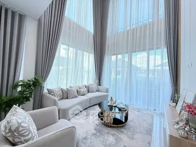 Luxurious living room with high ceilings and elegant decor in a modern home.