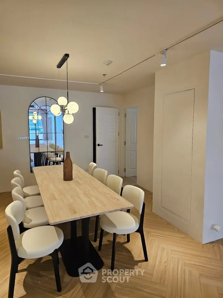 Elegant dining area with modern lighting and wooden table, perfect for entertaining guests.