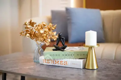 Elegant living room decor with stylish books, candle, and modern sculpture on a chic coffee table.