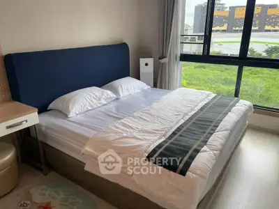 Spacious bedroom with large window offering a scenic view, featuring a comfortable bed and modern decor.