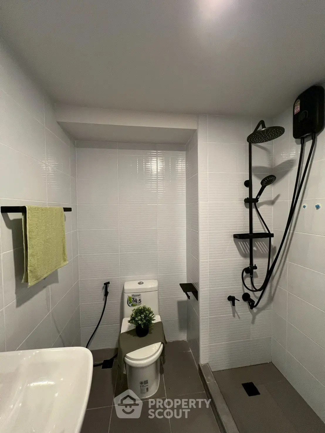 Modern bathroom with sleek shower and white tiles, featuring a compact layout.