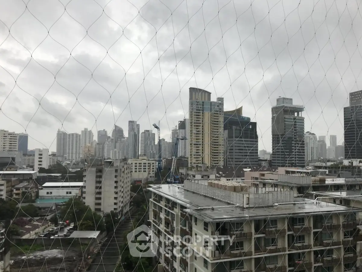 Stunning cityscape view from high-rise building on a cloudy day, showcasing urban skyline.
