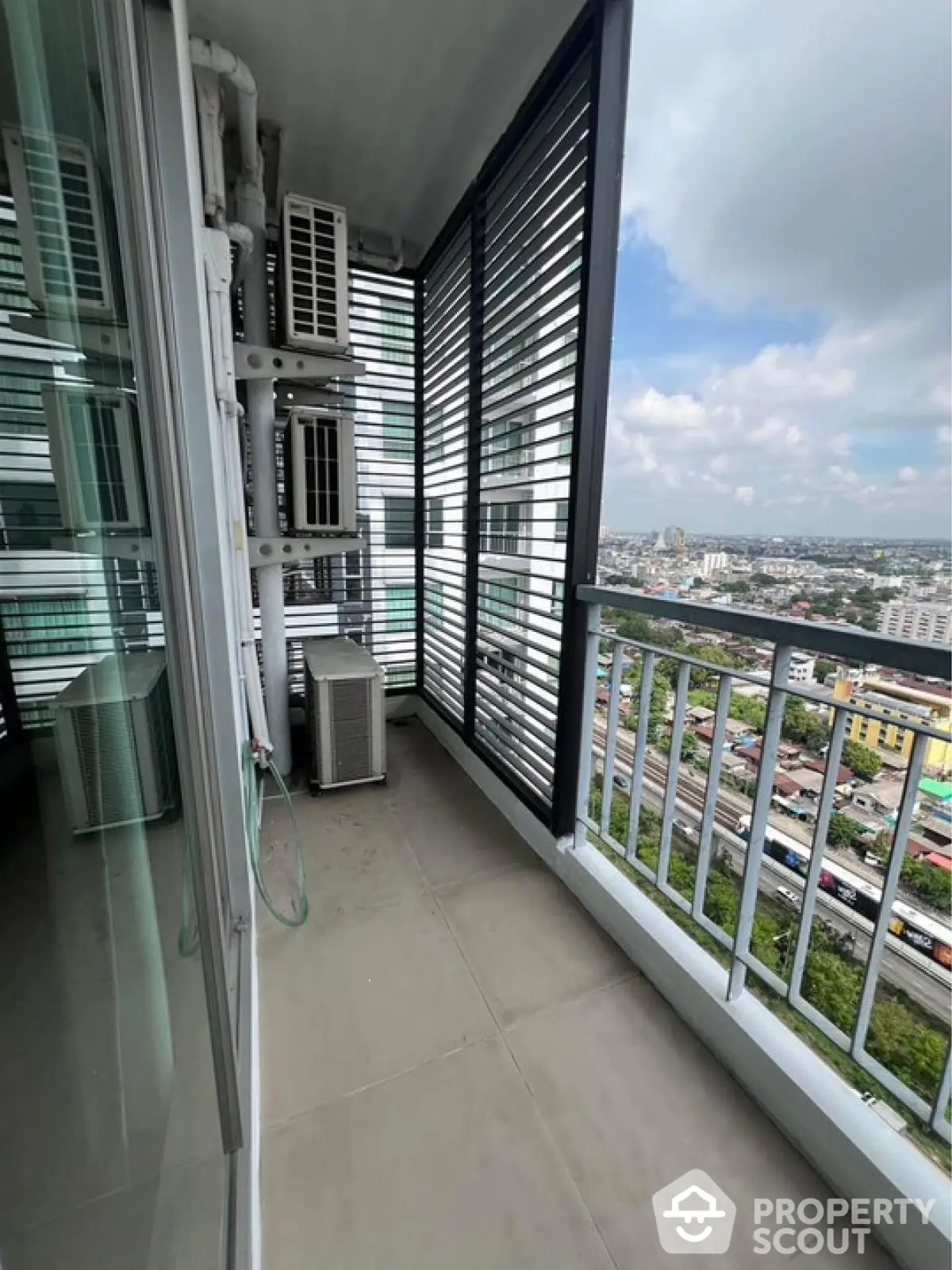 Modern balcony with city view and air conditioning units in high-rise building