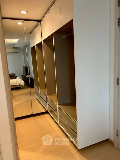 Stylish bedroom with mirrored wardrobe and modern design