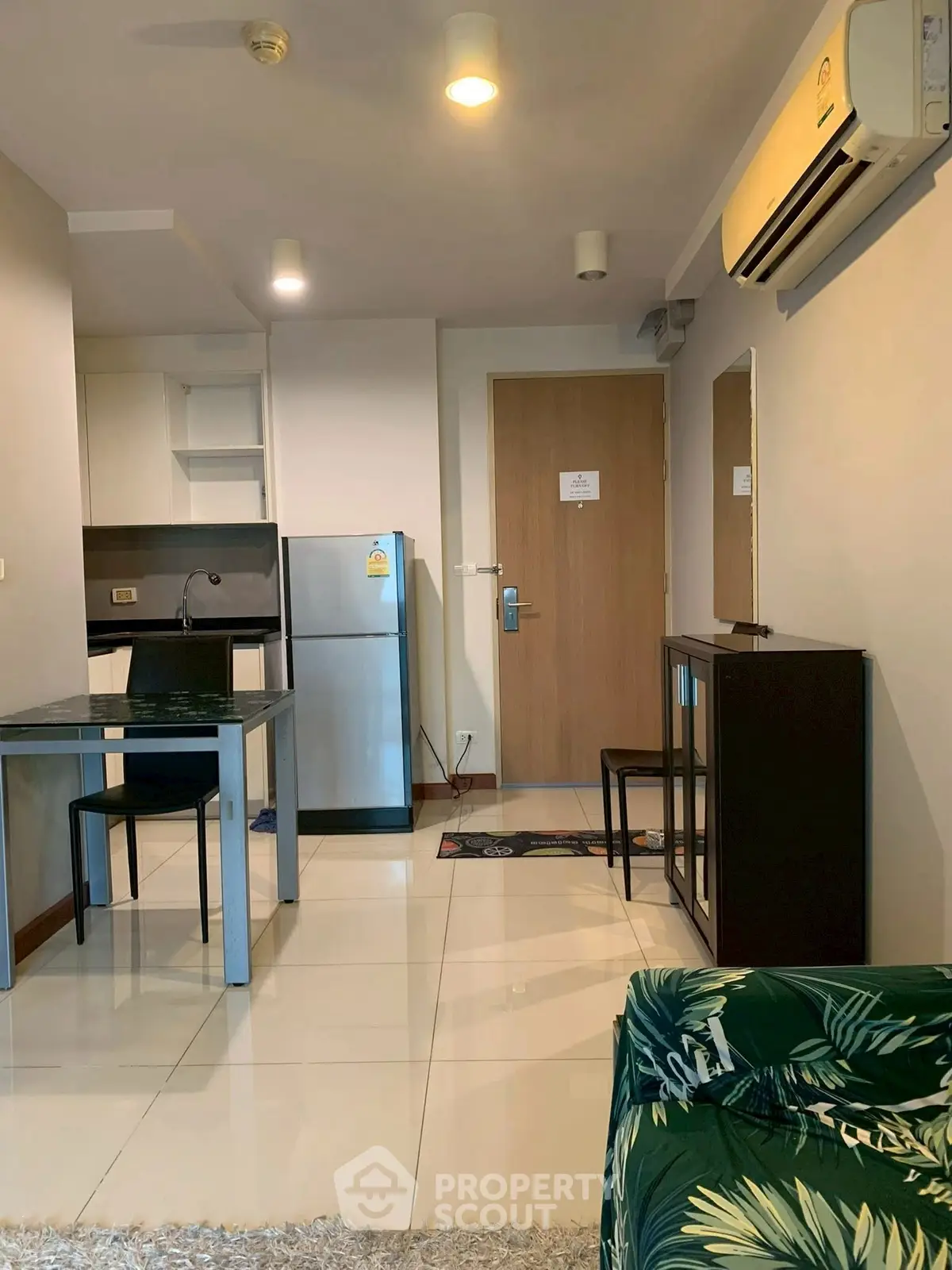 Modern apartment interior with sleek kitchen and dining area, featuring stainless steel appliances and stylish decor.