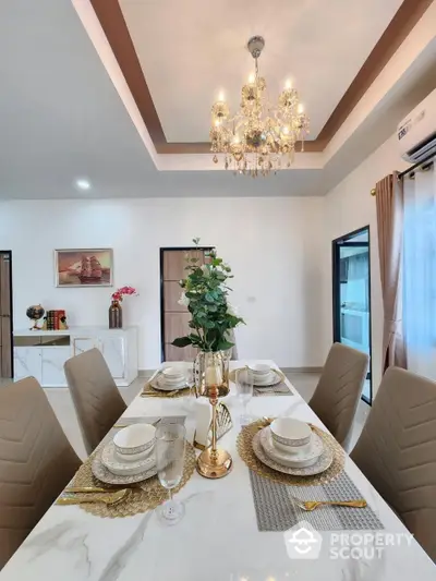 Elegant dining area with luxurious chandelier lighting, modern furniture, and tasteful decor, perfect for intimate dinners and entertaining guests.