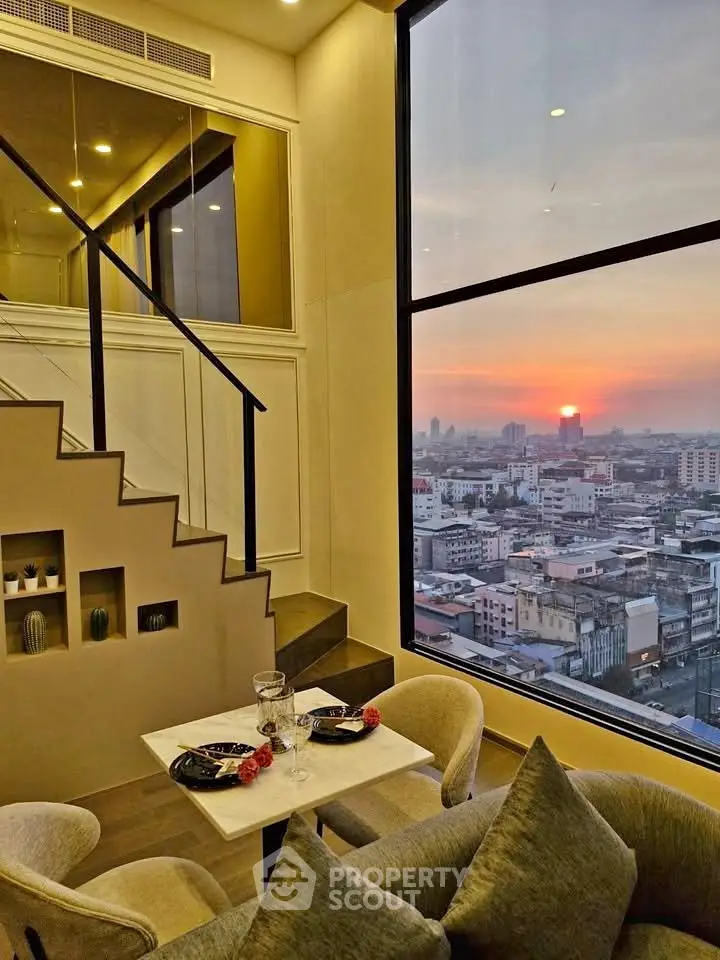 Stunning loft apartment with panoramic city view and elegant dining area at sunset.