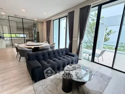 Luxurious modern living room with elegant furniture and large windows opening to a spacious balcony.