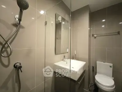 Modern bathroom with sleek fixtures and glass shower enclosure in a contemporary apartment.