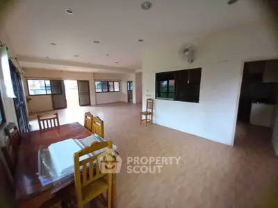 Spacious open-plan living area with dining table and ample natural light.