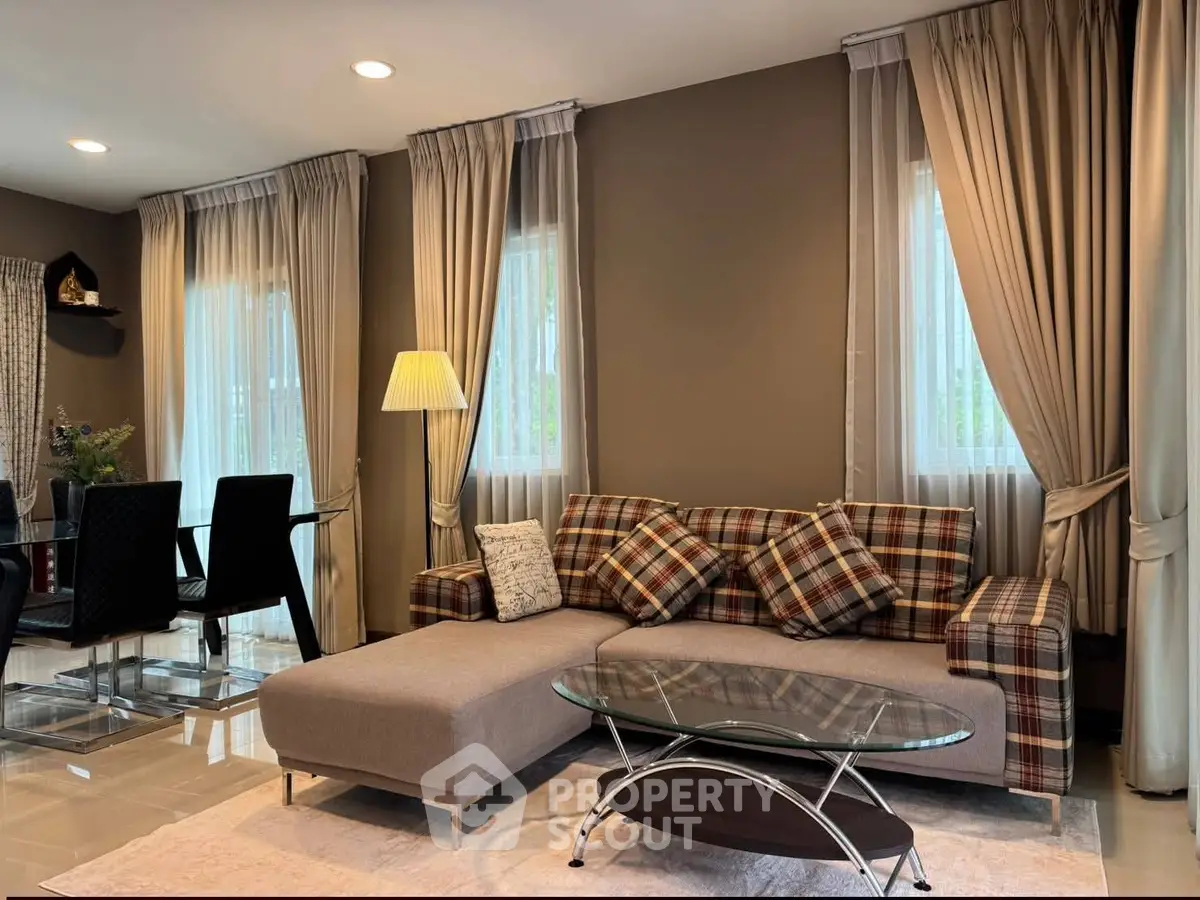 Elegant living room with stylish plaid sofa and modern glass coffee table, perfect for cozy gatherings.
