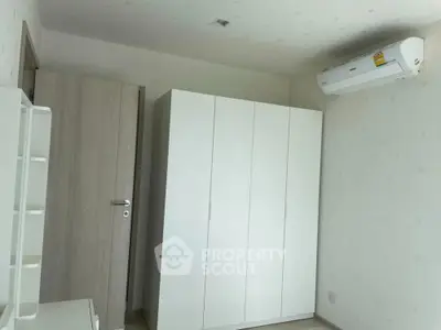 Minimalist bedroom with white wardrobe and air conditioning unit